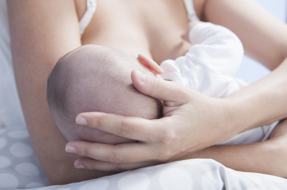 Mother,Holds,Her,Baby,Head,While,He,Is,Breastfed.,Closeup breast feeding